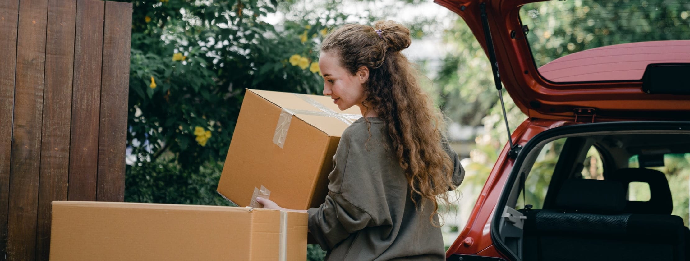 Woman taking moving boxes out of her car